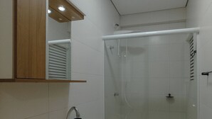 A bathroom with a sink, mirror, toilet, and glass-enclosed shower. - Top Location in the Heart of Maringa - JR509 (Maringá)
