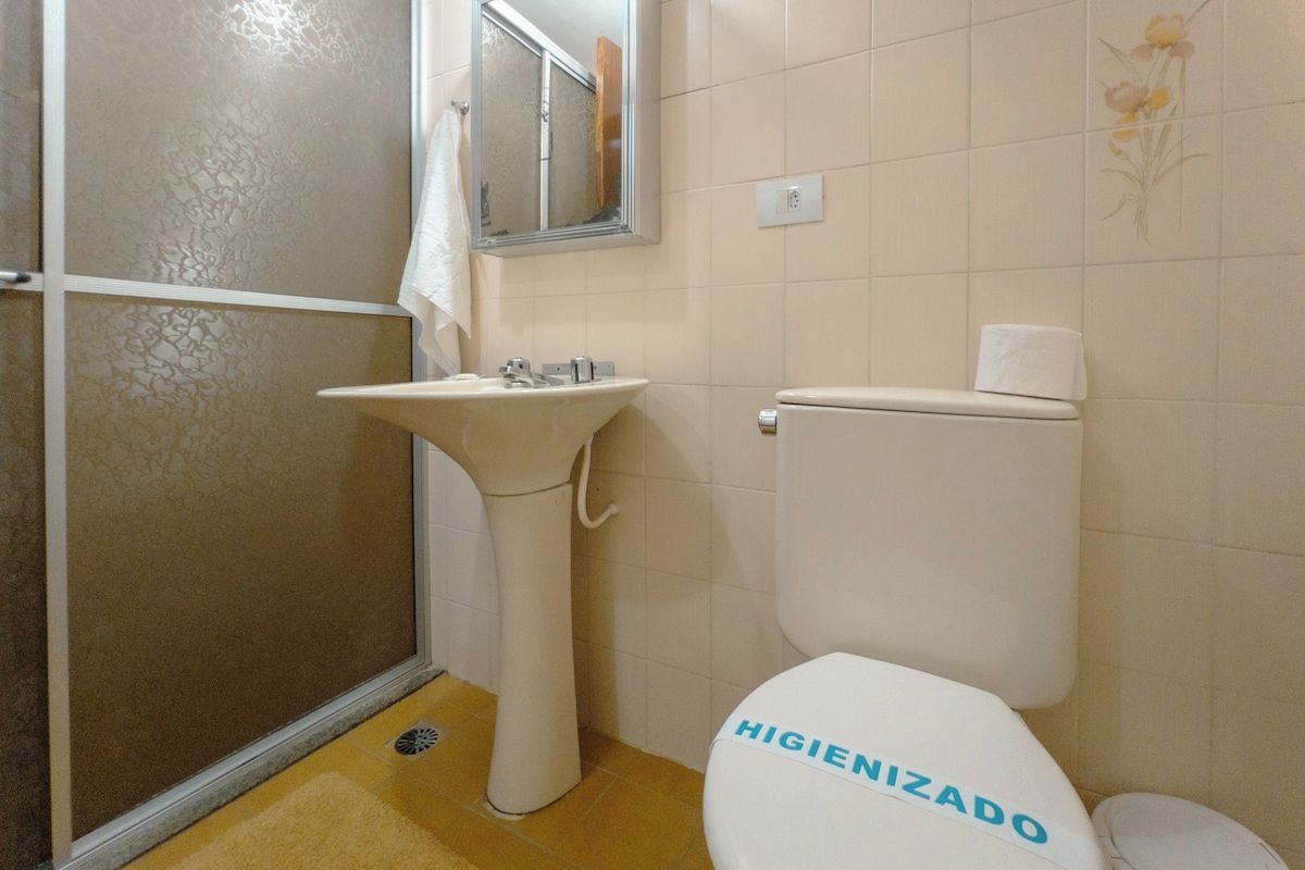 A bathroom with a toilet, sink, and shower area.