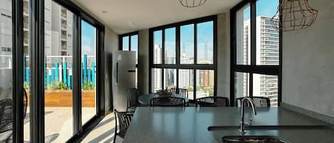 Une cuisine moderne dotée de grandes fenêtres, d’un plan de travail en granit et de luminaires suspendus.