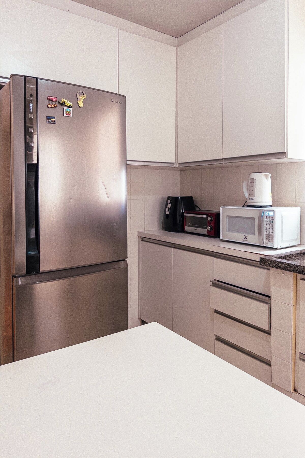 A kitchen with stainless steel appliances, including a refrigerator and a microwave.