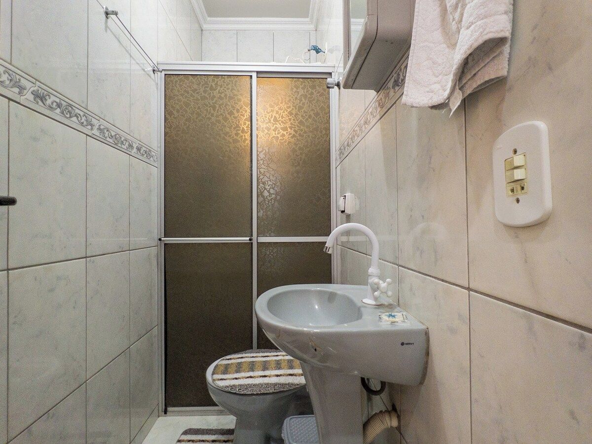 Un baño con ducha, inodoro y lavabo.