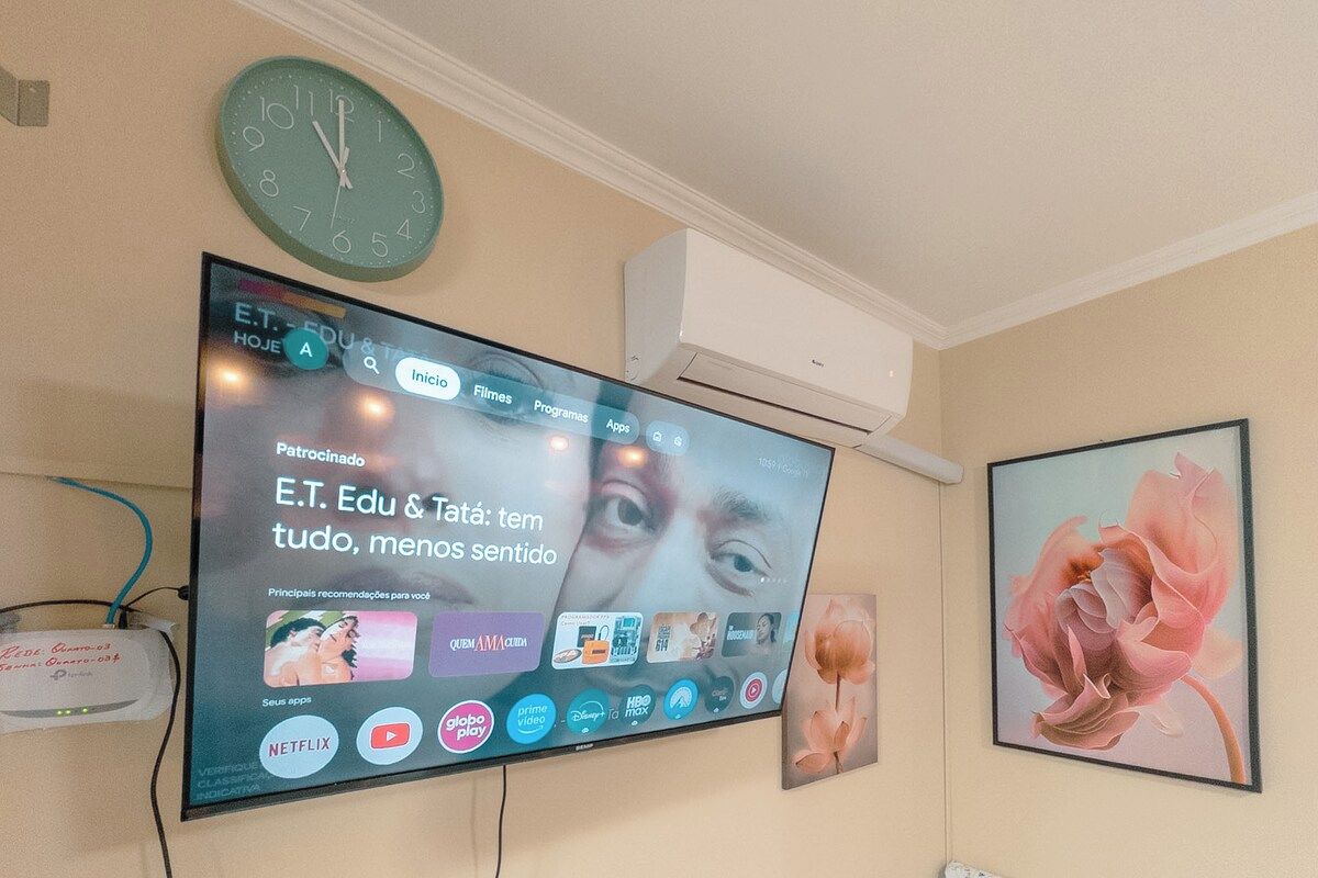 Ein an der Wand montierter Fernseher zeigt eine Streaming-Oberfläche mit verschiedenen App-Symbolen.
