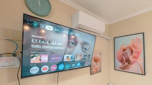 A television mounted on a wall displaying a streaming service interface with various app icons.