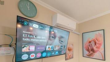 Ein an der Wand montierter Fernseher zeigt eine Streaming-Oberfläche mit verschiedenen App-Symbolen.