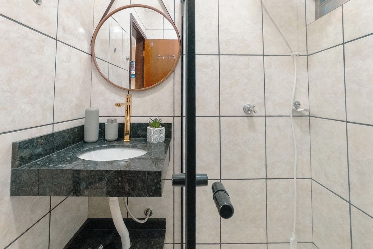 Casa de banho com lavatório, espelho e porta-toalhas.