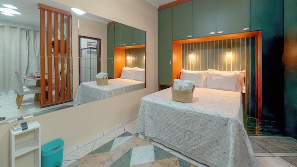 Habitación de hotel con dos camas, un espejo grande y un armario con espejo.