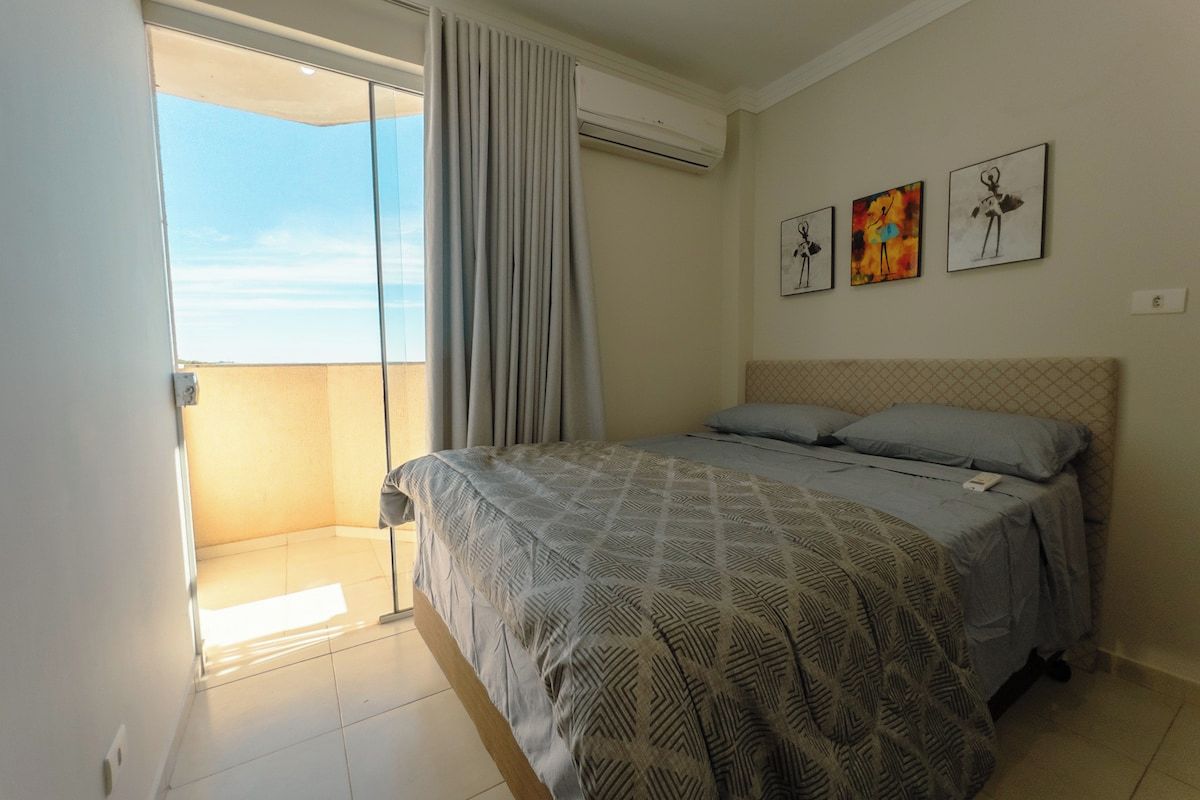 Un dormitorio con una cama, una ventana con cortinas y tres obras de arte colgadas en la pared.