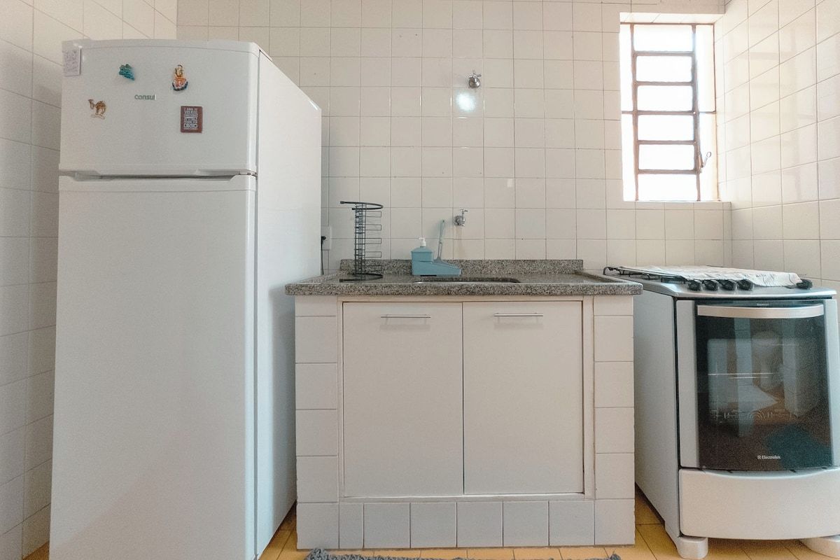 Uma cozinha com geladeira, fogão e armários.