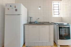 Uma cozinha com geladeira, fogão e armários.
