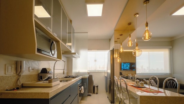 A modern kitchen with a central island, built-in appliances, and pendant lighting. - Modern Apartment in Zona 7 Maringa - MN704 (Maringá)