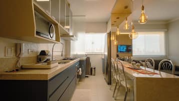 A modern kitchen with a central island, built-in appliances, and pendant lighting.