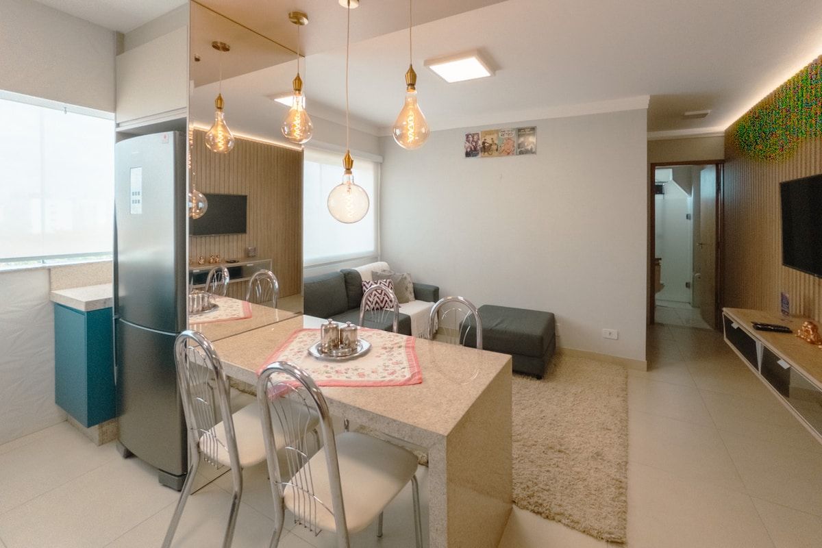 Une cuisine moderne avec une table à manger, des chaises et un réfrigérateur.