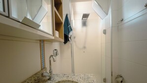 A bathroom with a sink, mirror, towel rack, shower, and toilet. - Modern Apartment in Zona 7 Maringa - MN704 (Maringá)