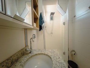Ein Badezimmer mit Waschbecken, Spiegel, Handtuchhalter, Dusche und Toilette.