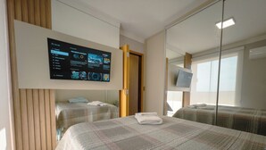 A hotel room with a large bed, a television mounted on the wall, and a mirror reflecting the room. - Modern Apartment in Zona 7 Maringa - MN704 (Maringá)