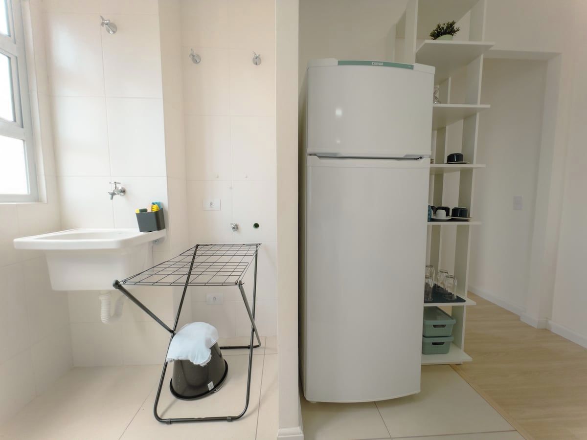 Una cocina pequeña con un lavabo, un escurreplatos y un refrigerador.