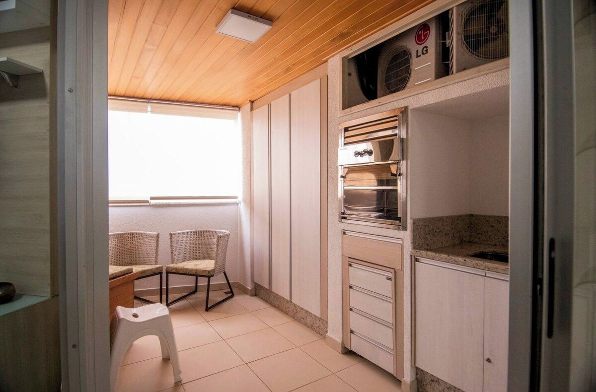 Cocina pequeña con armarios blancos, horno integrado y una encimera.