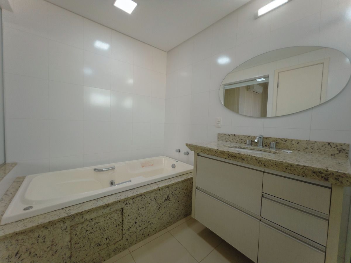 A bathroom with a bathtub, a sink, and a vanity with drawers.
