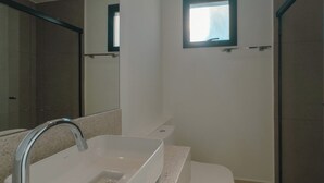 A bathroom with a white sink, a toilet, and a shower area. - Comfort and Style in Zona 7 for 5 Guests - BEDEO601 (Maringá)