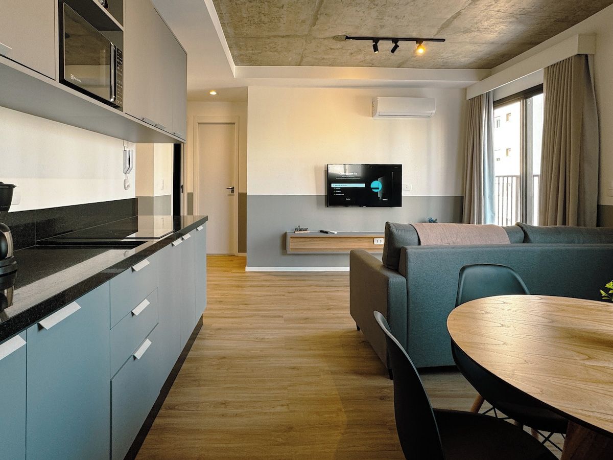 Una cocina moderna con microondas incorporado y un comedor con mesa redonda y sillas.