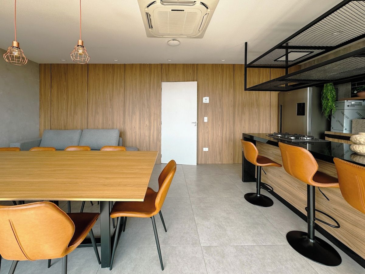 A modern kitchen with a wooden countertop, a built-in stove, and a hanging plant.