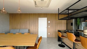 A modern kitchen with a wooden countertop, bar stools, and a built-in oven. - Modern Apartment in New Building - BEDEO505 (Maringá)