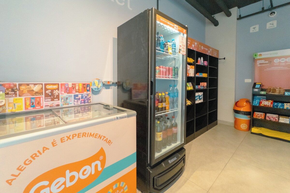 A refrigerated display with a Geben advertisement and a shelf stocked with various beverages.