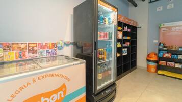 A refrigerated display with a Geben advertisement and a shelf stocked with various beverages.