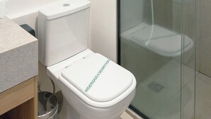 A modern bathroom with a toilet, a glass shower enclosure, and a sink. - Private Room with Pool and Gym - BEDEO302B (Maringá)