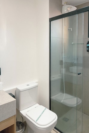 A modern bathroom with a toilet, a glass shower enclosure, and a sink. - Private Room with Pool and Gym - BEDEO302B (Maringá)