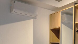 A hotel room with a bed, a wardrobe, and a mirror. - Private Room with Pool and Gym - BEDEO302B (Maringá)