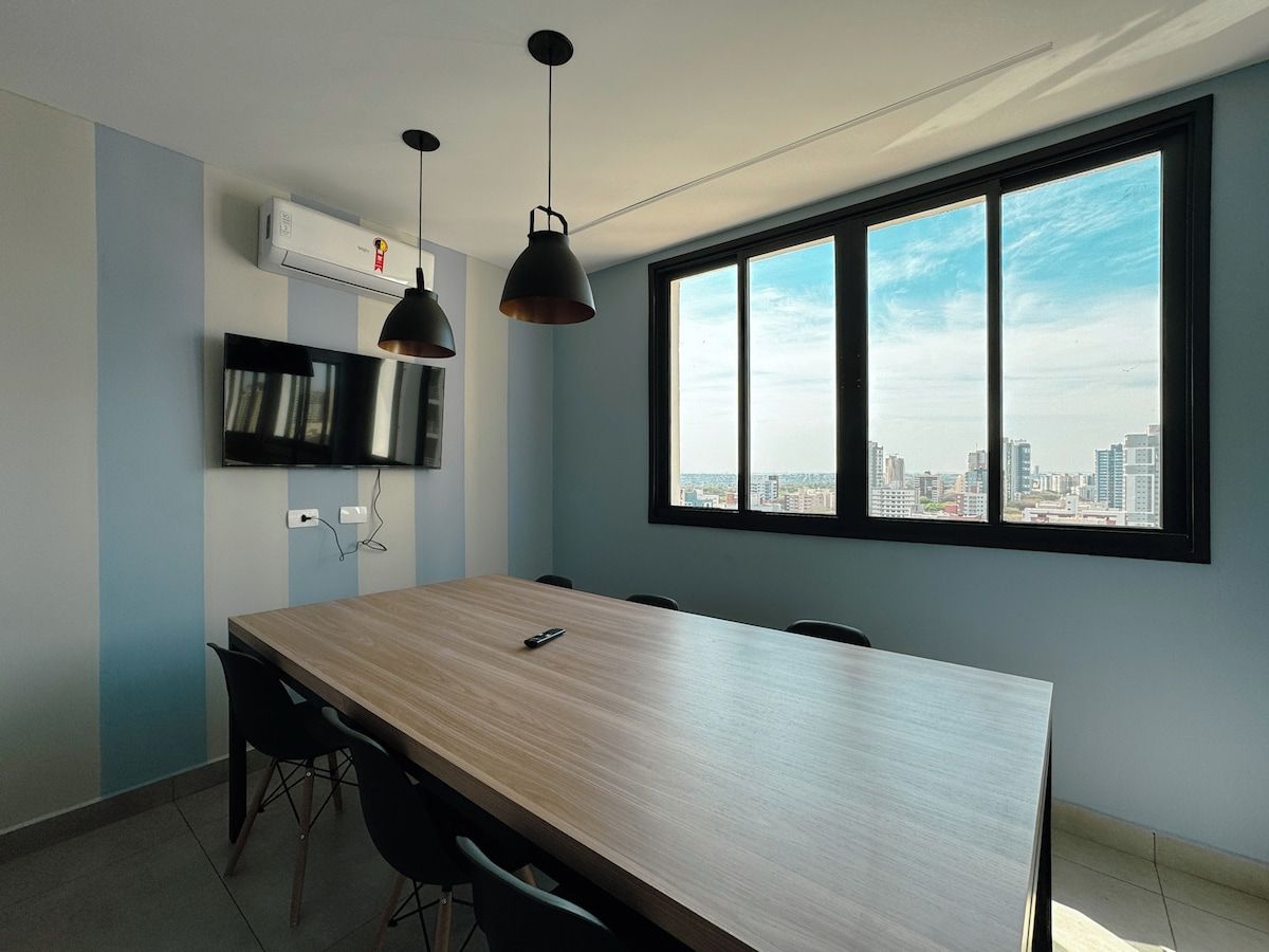 Una cocina moderna con una isla grande, horno empotrado y ventana con vistas a la ciudad.