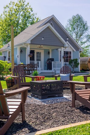 A house with a porch, outdoor seating, and a fire pit.