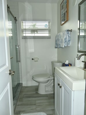 A bathroom with a toilet, sink, and shower. - Linen and Palm 1bed/1bath heart of Fort Lauderdale (Fort Lauderdale)