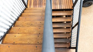 Eine Holztreppe mit Metallgeländern, die zu einer oberen Ebene führt.