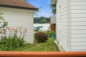 A residential property with a view of a lake, a dock, and a boat. - Cedar Lake Sunrise: 1BR, 1.5 Bath with Lake View and Back Porch (Cedar Lake)