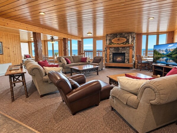 A spacious living room with a fireplace, multiple seating options, and a television.