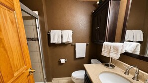 Een badkamer met toilet, wastafel en handdoekrek.