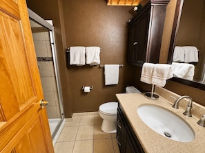Une salle de bain équipée de toilettes, d’un lavabo et d’un porte-serviettes.