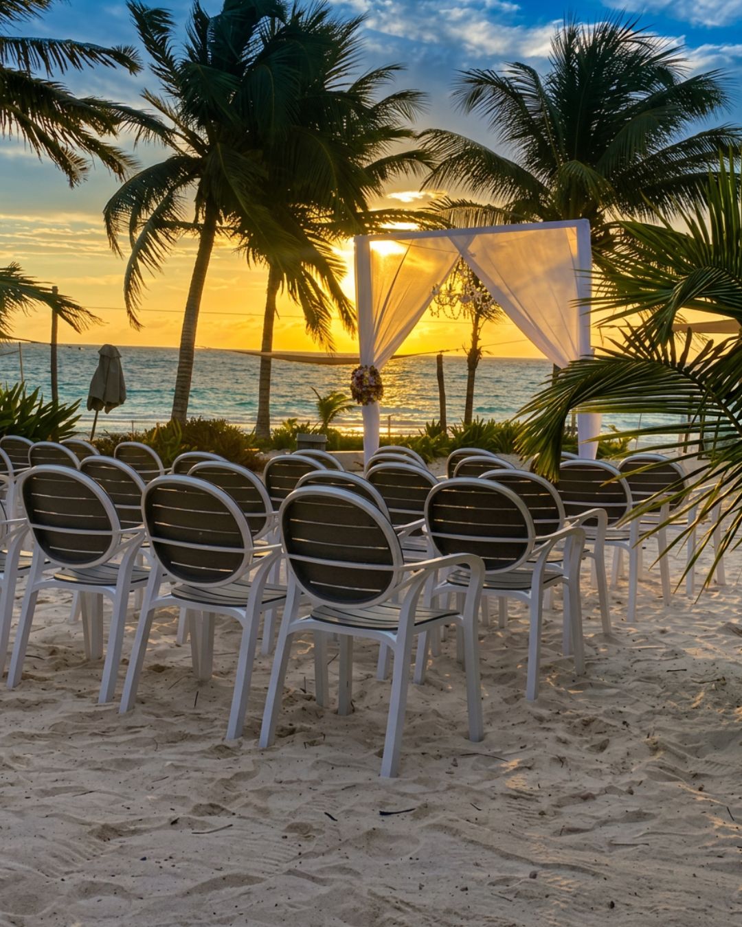 Een stranddecor met een witte luifel en stoelen, ingericht voor een evenement.