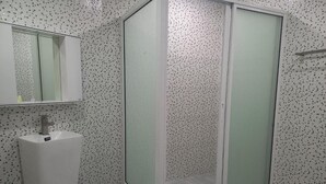A bathroom with a shower enclosure, a sink, and a mirror. - Dania Pattaya (Pattaya)