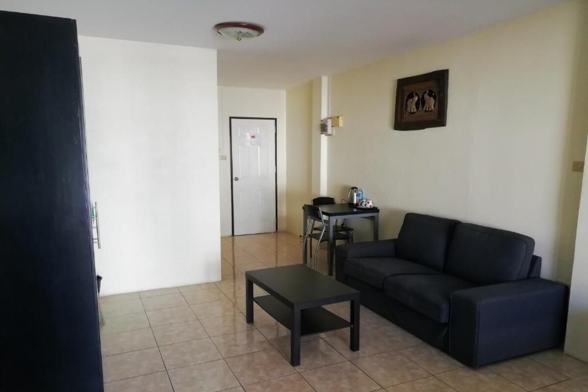 Ein Wohnzimmer mit einer Couch, einem Couchtisch und einer Tür zu einem anderen Raum.