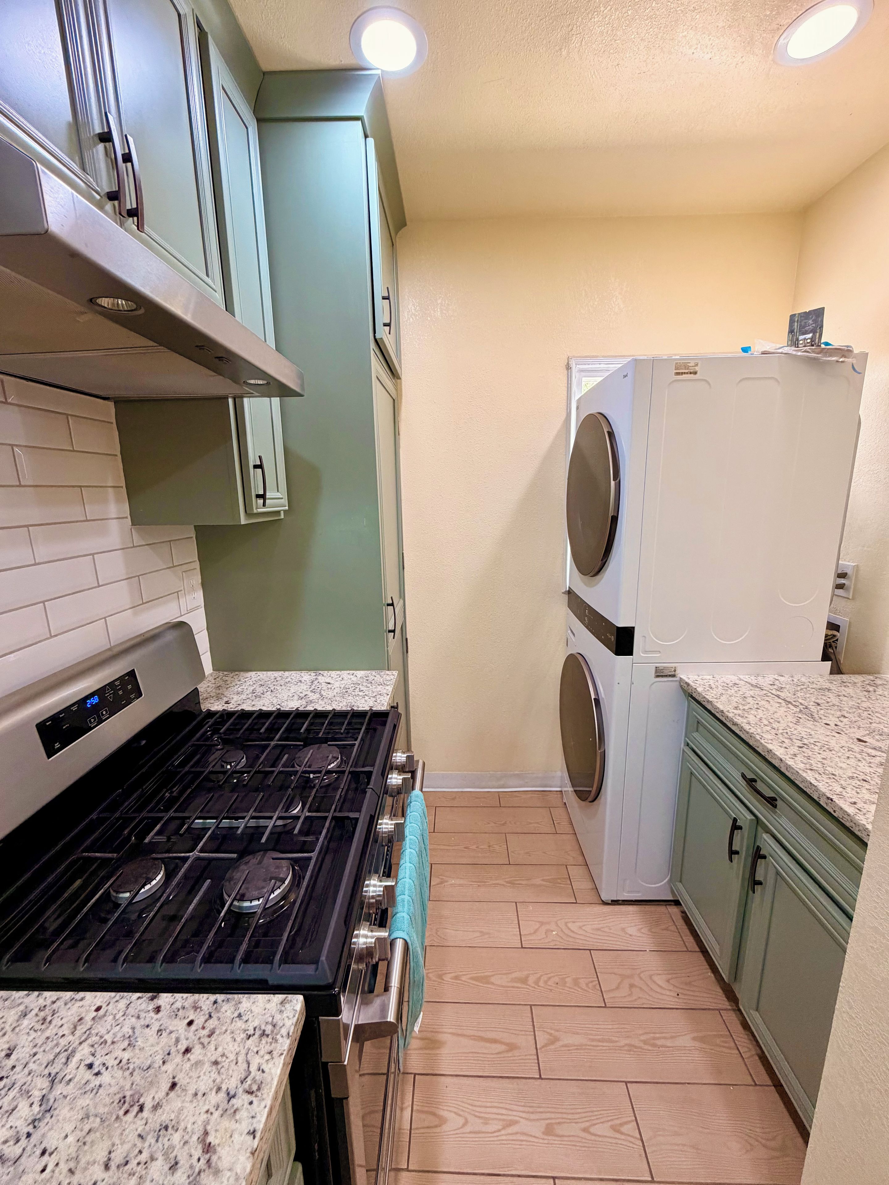 A kitchen with a stove, oven, and a washing machine.