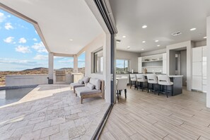 A modern kitchen with white cabinets and a bar area. - The Mountain Watch | Infinity Pool & Casita (Fountain Hills)