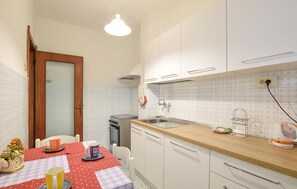 A compact kitchen with white cabinets, a wooden countertop, and a tiled backsplash. - 2 bedroom stunning apartment in Deiva Marina (Deiva Marina)
