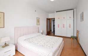 A bedroom with a bed, a nightstand, a wardrobe, and a chair. - 2 bedroom stunning apartment in Deiva Marina (Deiva Marina)