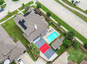Une propriété résidentielle dotée d’une piscine, d’un patio couvert et d’une cour clôturée.