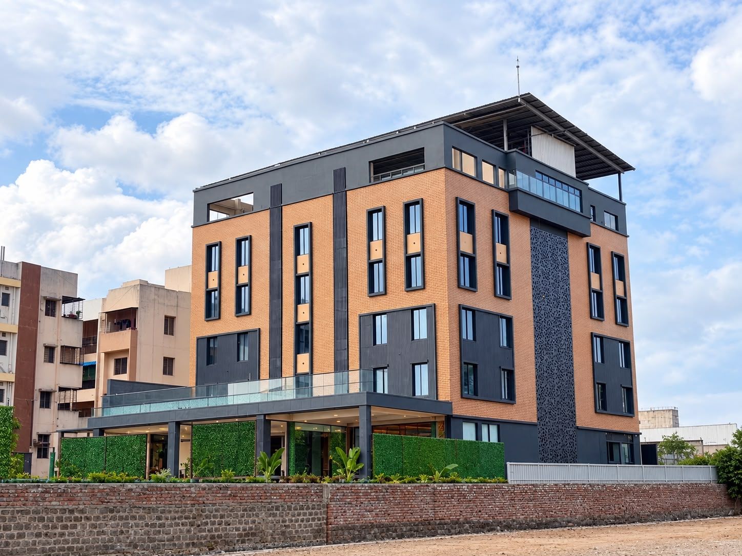 A multi-story building with a flat roof, large windows, and a brick facade.