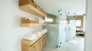 A modern kitchen with wooden shelves, a glass refrigerator, and a wooden cabinet.