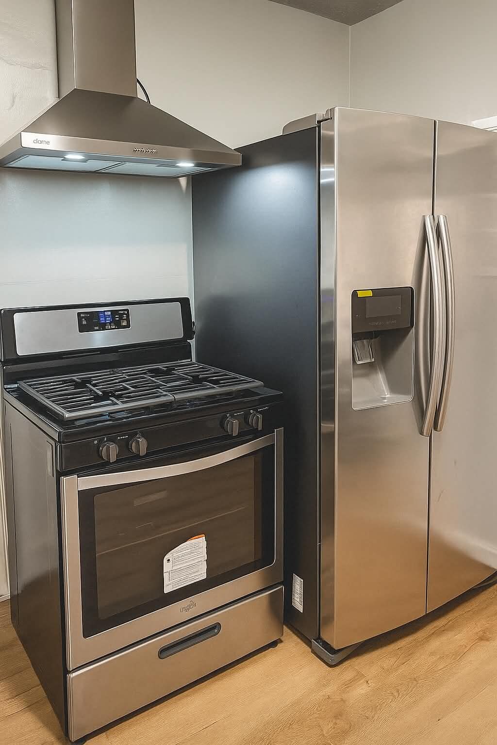 Una cocina con estufa, horno y refrigerador de acero inoxidable.